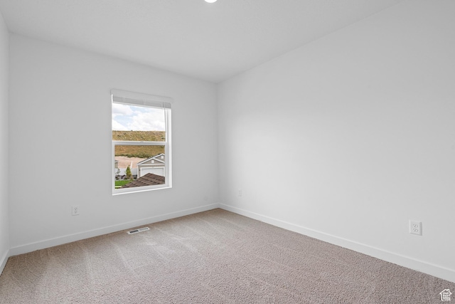carpeted empty room with visible vents and baseboards