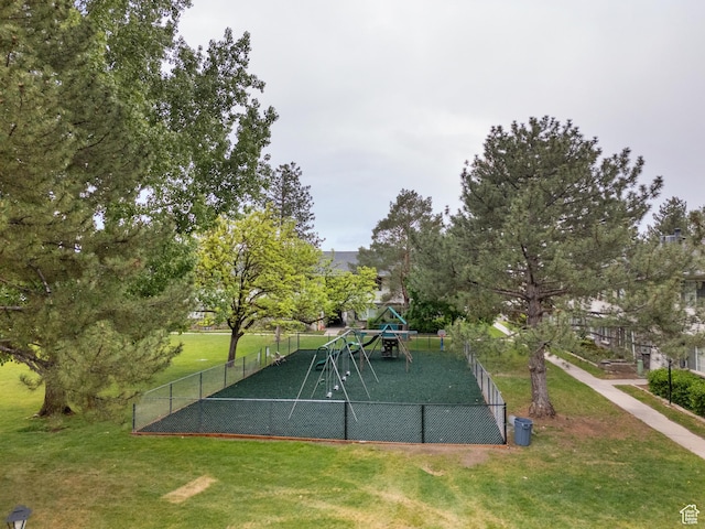 surrounding community featuring fence, playground community, and a lawn
