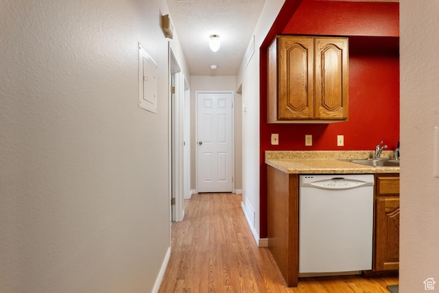 hall with a sink, baseboards, and light wood-style floors