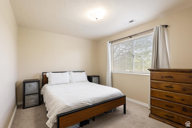 bedroom with baseboards, visible vents, and carpet floors