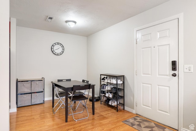 dining area with light wood-style floors, visible vents, and baseboards