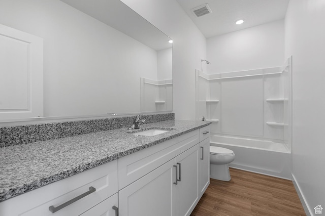 full bathroom featuring shower / bath combination, toilet, visible vents, vanity, and wood finished floors