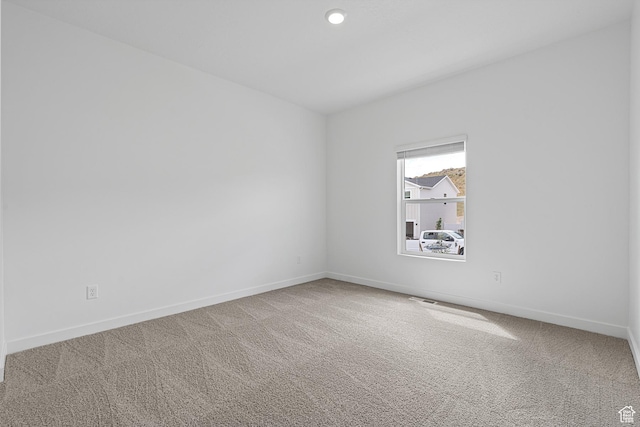carpeted spare room featuring visible vents, baseboards, and recessed lighting