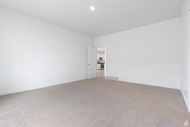 unfurnished room featuring light colored carpet, baseboards, visible vents, and recessed lighting