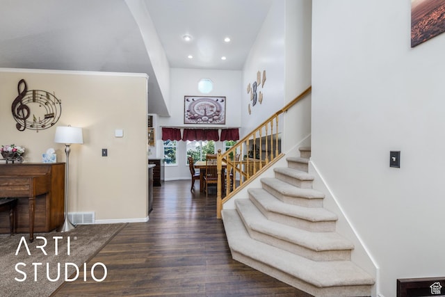 foyer featuring recessed lighting, baseboards, a towering ceiling, wood finished floors, and stairway