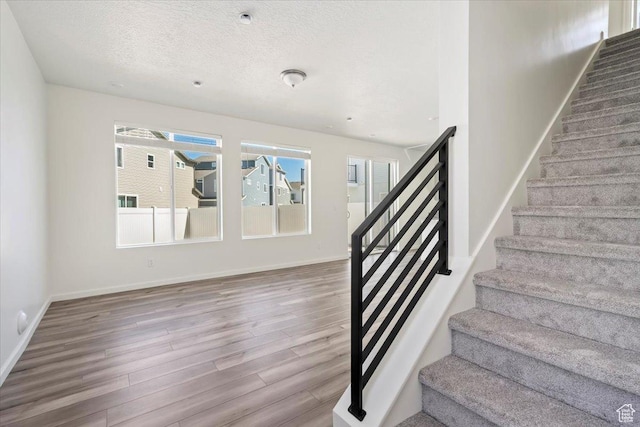 353 N Colonnade Rd Unit 1007, Saratoga Springs, UT 84045 - staircase with a textured ceiling, wood finished floors, and baseboards