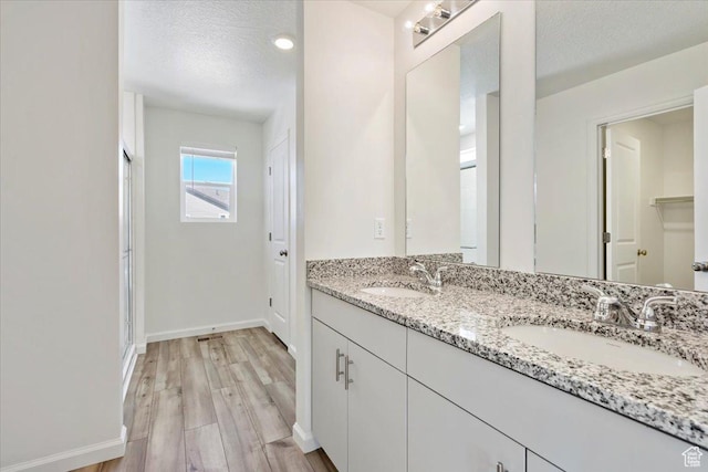 353 N Colonnade Rd Unit 1007, Saratoga Springs, UT 84045 - bathroom featuring a sink, a textured ceiling, baseboards, and wood finished floors