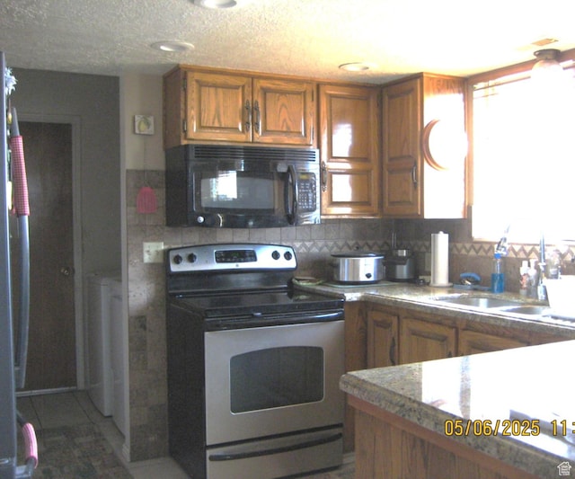 18235 N 4400 W, Fielding, UT 84311 - kitchen featuring backsplash, appliances with stainless steel finishes, brown cabinetry, and a sink