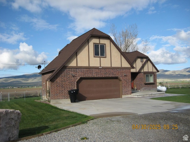 18235 N 4400 W, Fielding, UT 84311 - view of side of home with a yard, fence, a mountain view, and concrete driveway