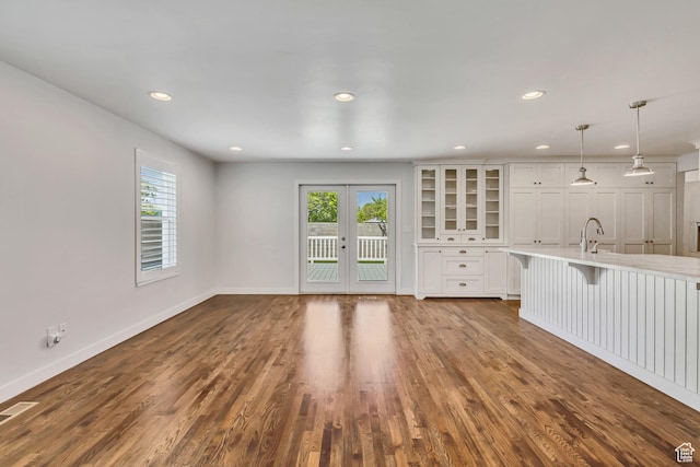 unfurnished living room with plenty of natural light, baseboards, dark wood-style floors, and recessed lighting