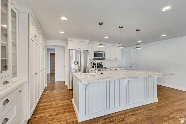 kitchen with glass insert cabinets, white cabinets, baseboards, backsplash, and appliances with stainless steel finishes
