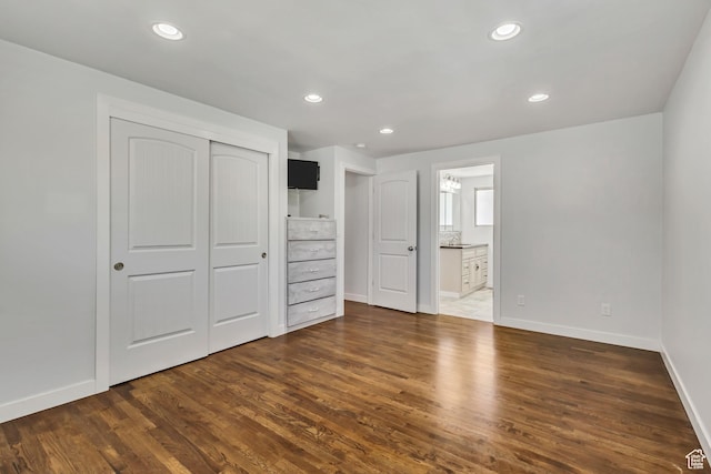 unfurnished bedroom with recessed lighting, baseboards, a closet, and dark wood finished floors