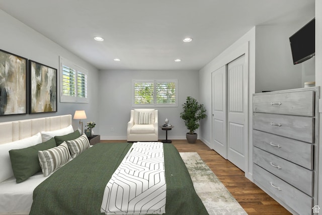 bedroom with baseboards, dark wood-style floors, a closet, and recessed lighting