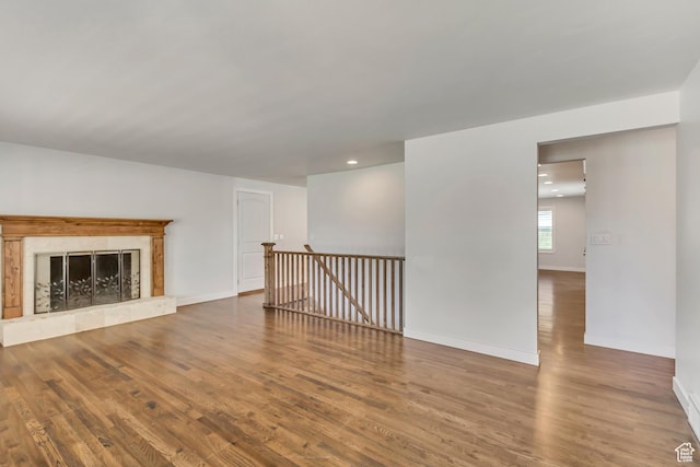 unfurnished living room featuring baseboards, recessed lighting, and wood finished floors