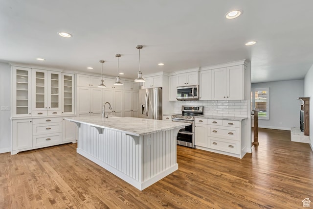 kitchen with white cabinetry, stainless steel appliances, baseboards, and recessed lighting