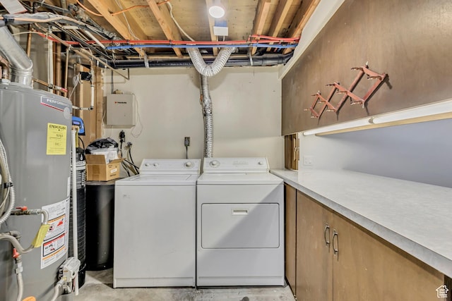 clothes washing area featuring washing machine and clothes dryer, laundry area, and gas water heater