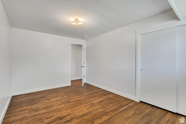 unfurnished bedroom featuring baseboards, a closet, and wood finished floors