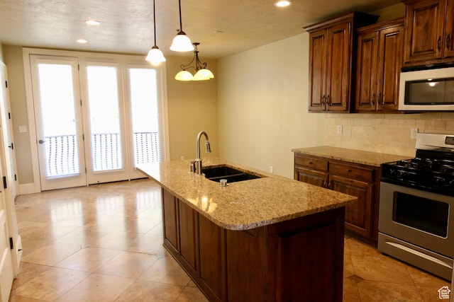 kitchen with a sink, stainless steel range with gas stovetop, white microwave, backsplash, and recessed lighting