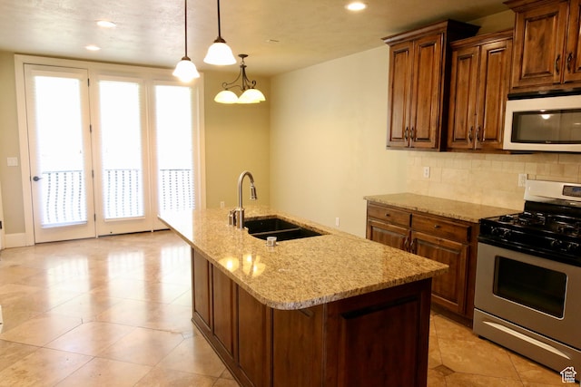 kitchen featuring stainless steel range with gas cooktop, a healthy amount of sunlight, white microwave, and a sink