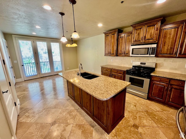 kitchen featuring stainless steel range with gas stovetop, backsplash, baseboards, and a sink