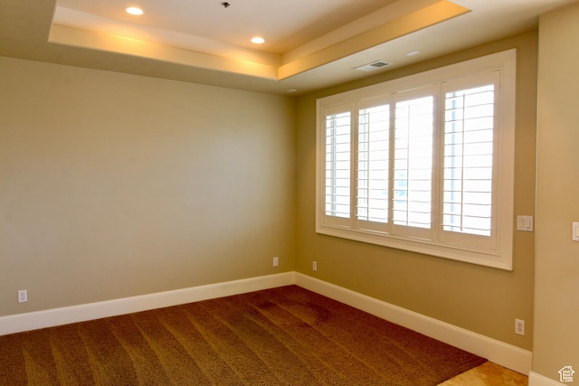 unfurnished room with visible vents, a raised ceiling, a healthy amount of sunlight, and recessed lighting