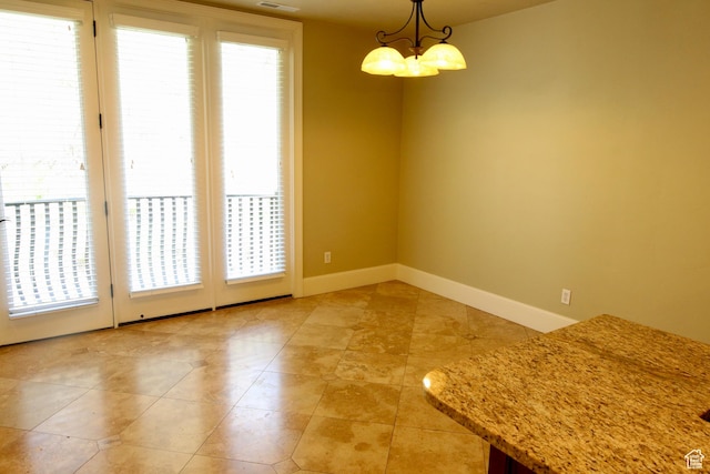 unfurnished dining area featuring a chandelier, baseboards, light tile patterned floors, and visible vents