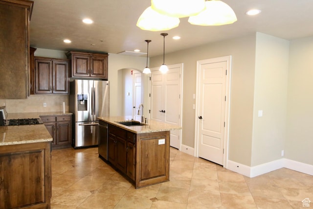 kitchen featuring recessed lighting, stainless steel appliances, arched walkways, and a sink