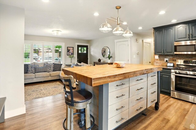 569 N 700 E, Mapleton, UT 84664 - kitchen featuring light wood-type flooring, stainless steel appliances, a breakfast bar area, and butcher block counters