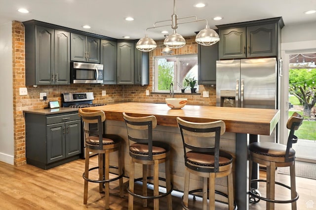 569 N 700 E, Mapleton, UT 84664 - kitchen with wood counters, a healthy amount of sunlight, stainless steel appliances, and decorative backsplash