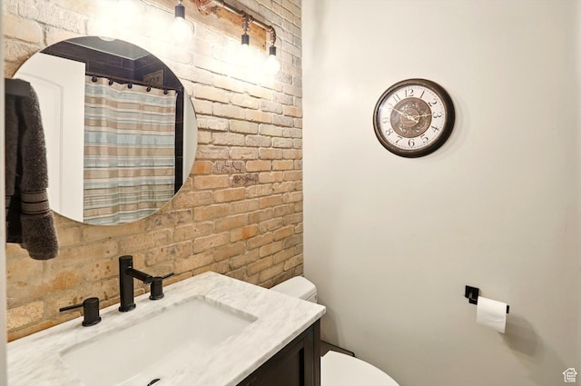 569 N 700 E, Mapleton, UT 84664 - bathroom featuring toilet, curtained shower, brick wall, and vanity