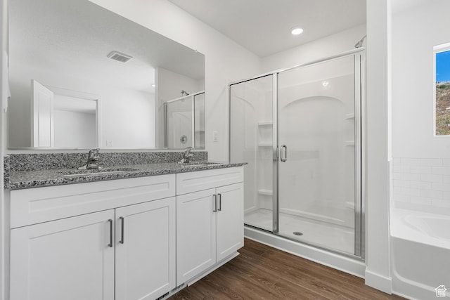 bathroom featuring double vanity, visible vents, a shower stall, and a sink