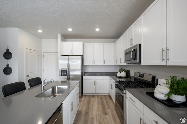 2522 N Wildwood Ln E Unit 240, Heber City, UT 84032 - kitchen with appliances with stainless steel finishes, light wood-style floors, recessed lighting, white cabinets, and a textured ceiling
