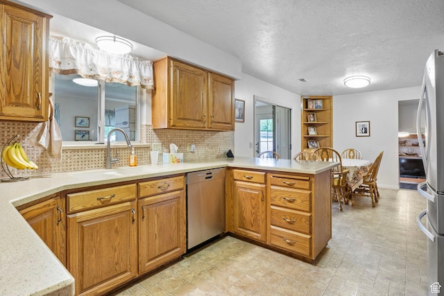 235 W 1000 N, Bountiful, UT 84010 - kitchen featuring a peninsula, a sink, stainless steel appliances, backsplash, and light countertops