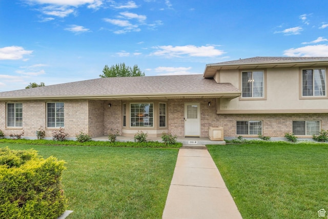 tri-level home featuring a front yard and brick siding