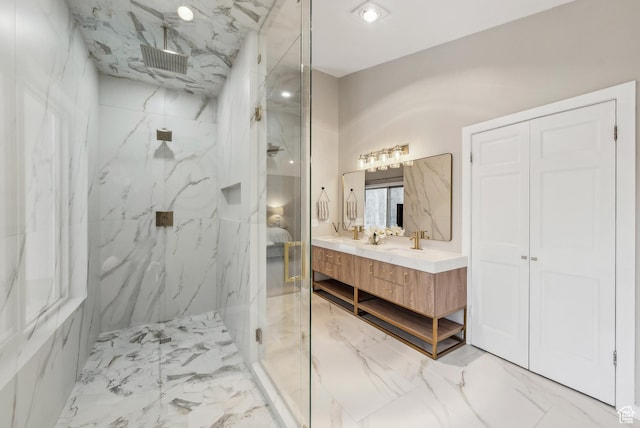 ensuite bathroom with a marble finish shower, marble finish floor, ensuite bathroom, and vanity