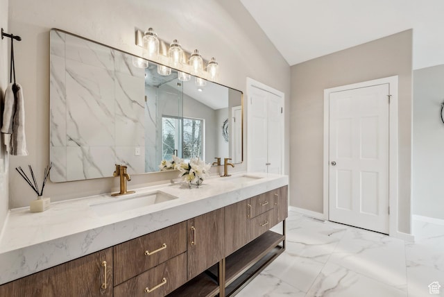 bathroom with lofted ceiling, marble finish floor, double vanity, and a sink