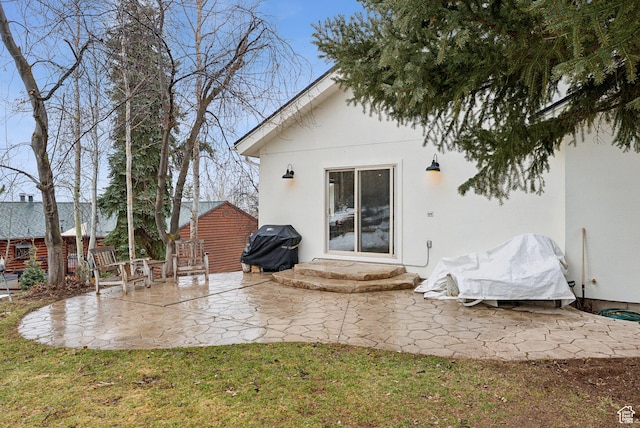 back of property featuring a yard, a patio, and stucco siding