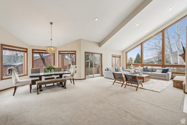 dining space with a chandelier, lofted ceiling, light colored carpet, and baseboards