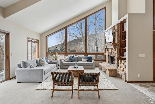 carpeted living room featuring baseboards, a stone fireplace, and a high ceiling