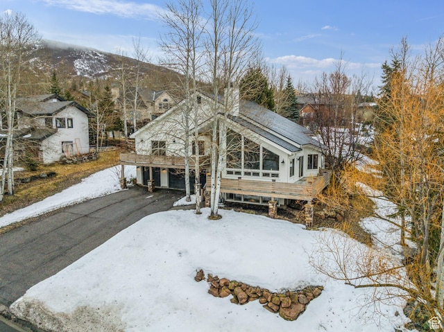 view of front of property featuring a chimney, aphalt driveway, and a mountain view