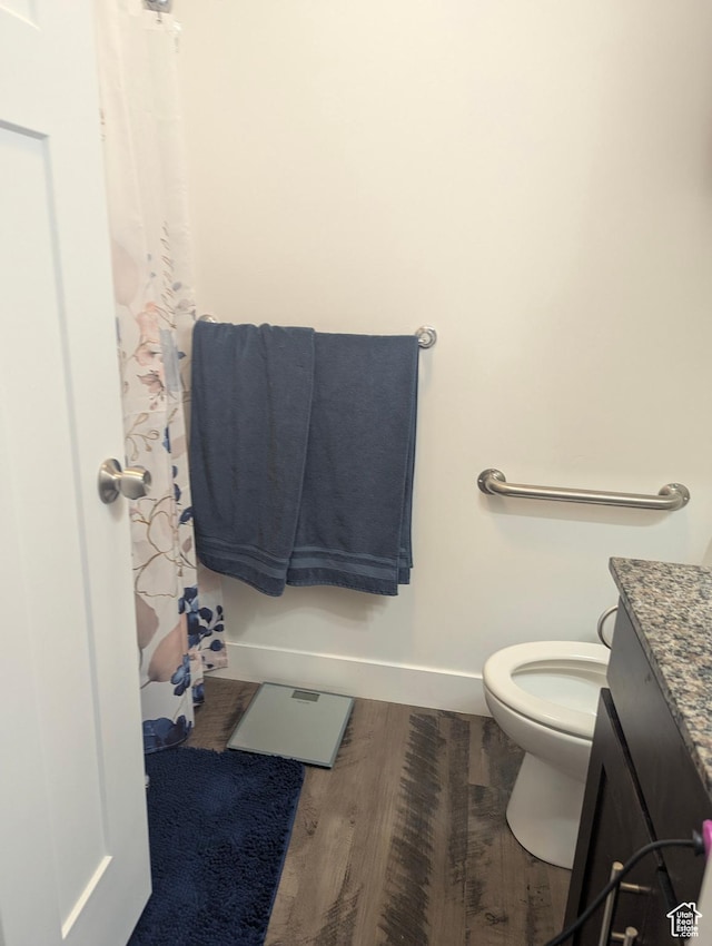 621 Shay Ln, Tooele, UT 84074 - bathroom with toilet, baseboards, wood finished floors, vanity, and a shower with curtain