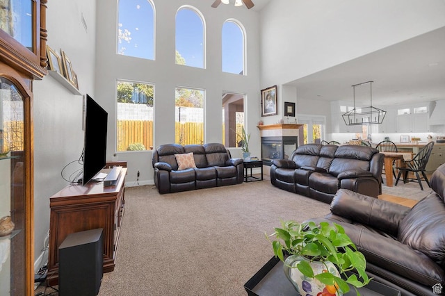1056 W 100 N, St George, UT 84770 - carpeted living room with a high ceiling, a ceiling fan, a healthy amount of sunlight, and a glass covered fireplace