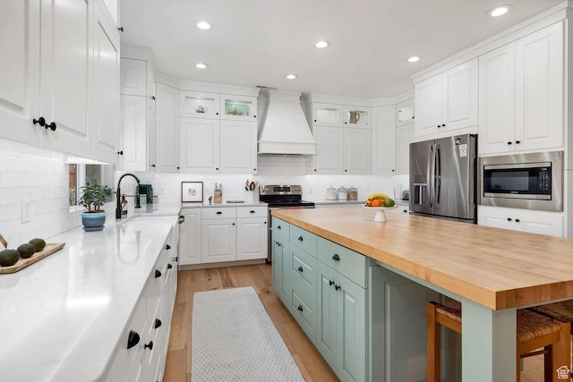1056 W 100 N, St George, UT 84770 - kitchen with wood counters, stainless steel appliances, white cabinets, and custom exhaust hood