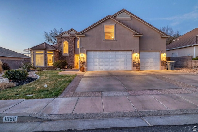 1056 W 100 N, St George, UT 84770 - traditional-style house with concrete driveway, a garage, stucco siding, and stone siding