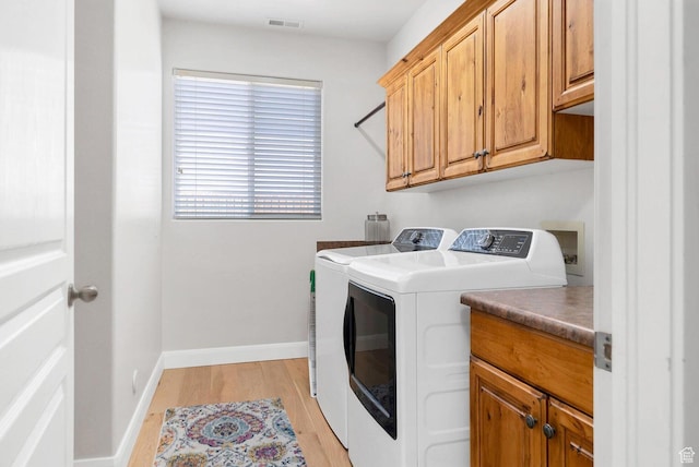 1056 W 100 N, St George, UT 84770 - clothes washing area with cabinet space, visible vents, light wood-style flooring, washing machine and dryer, and baseboards