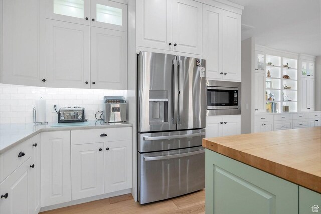 1056 W 100 N, St George, UT 84770 - kitchen with wooden counters, light wood-style flooring, white cabinets, appliances with stainless steel finishes, and decorative backsplash
