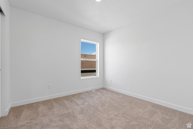 carpeted empty room with baseboards and visible vents