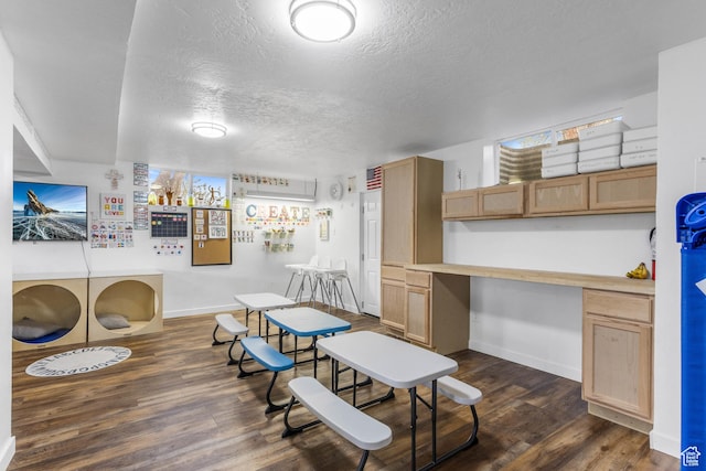 interior space featuring a textured ceiling, dark wood-style floors, baseboards, and built in study area