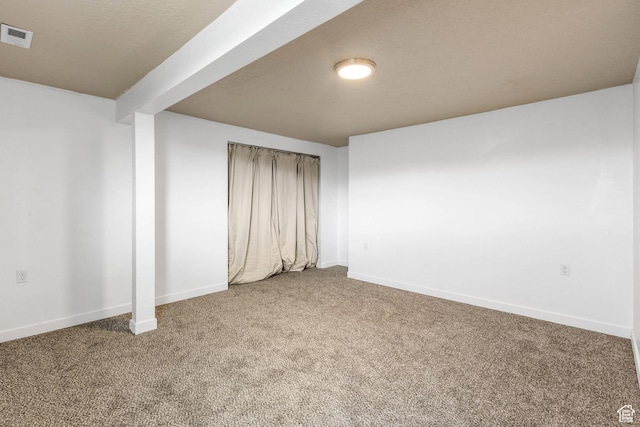 below grade area featuring baseboards, visible vents, and carpet