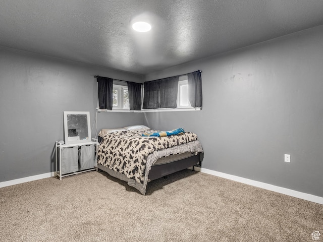 carpeted bedroom with a textured ceiling and baseboards
